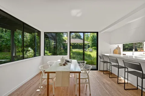 a kitchen with a refrigerator a stove a sink and white cabinets with wooden floor