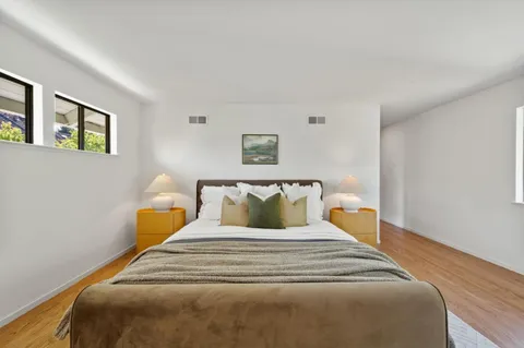 a bedroom with a bed and a large window
