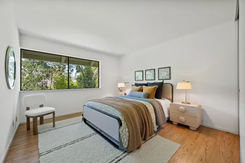 a bedroom with a bed and a large window