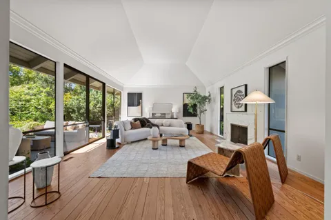 a living room with fireplace furniture and a large window