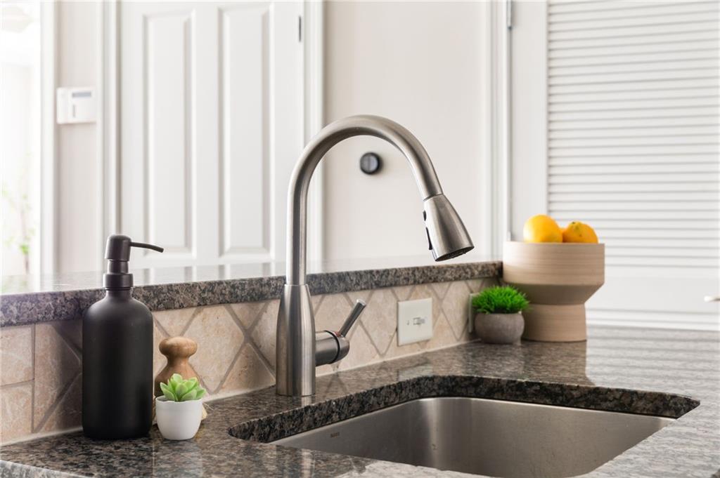 2255 Peachtree Road Northeast, Unit 326 Atlanta, GA 30309 - Photo 9 of 37 a kitchen with a faucet a potted plant and a window
