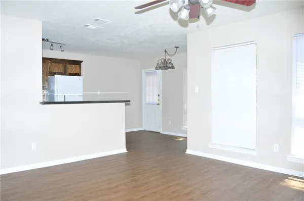 a view of a room with wooden floor and chandelier fan