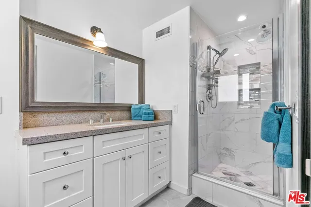 a bathroom with a granite countertop sink and a mirror