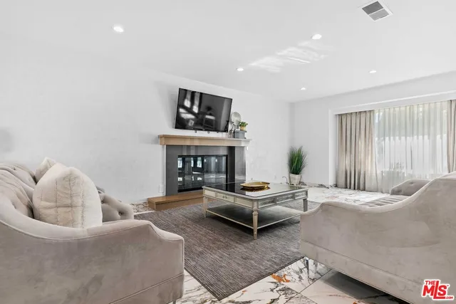 a living room with furniture a fireplace and a flat screen tv