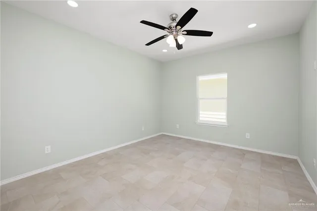 an empty room with a window and a fan
