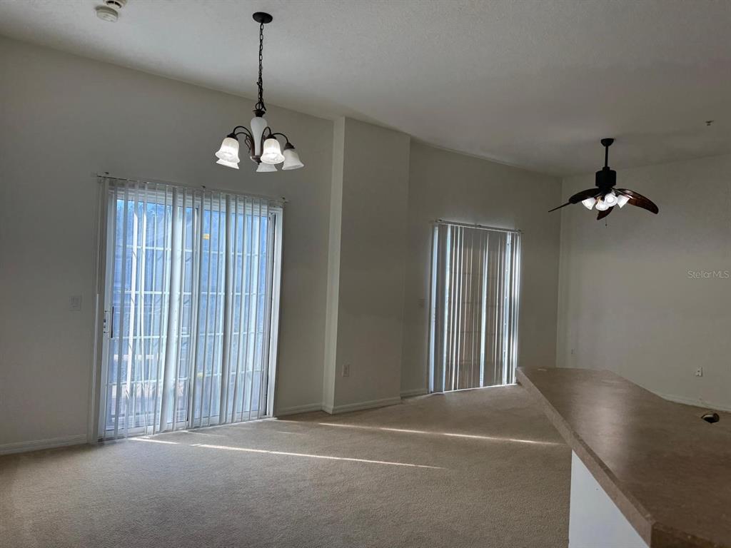 6404 South Goldenrod Road, Unit 2A Orlando, FL 32822 - Photo 9 of 21 a view of a livingroom with a chandelier fan and windows