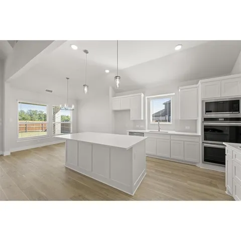 a kitchen with white cabinets and window