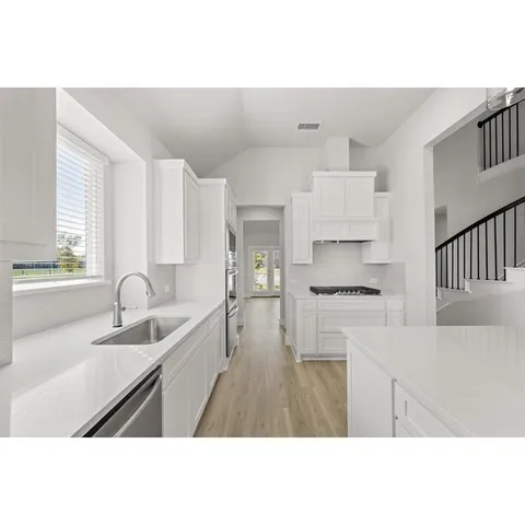 a open kitchen with kitchen island white cabinets and stainless steel appliances
