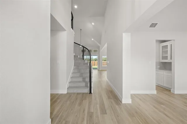 a view of a hallway with wooden floor and entryway