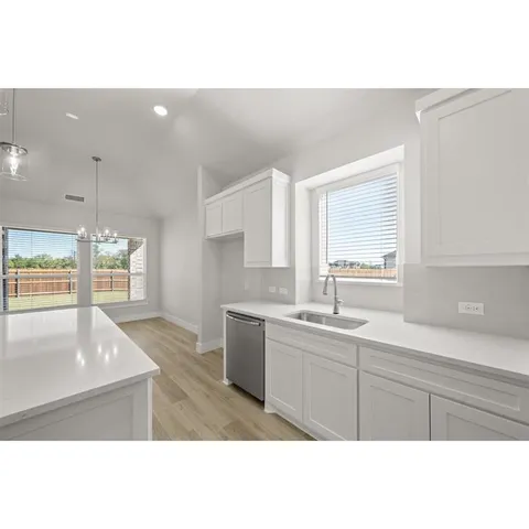 a living room with stainless steel appliances kitchen island granite countertop a sink cabinets and wooden floor