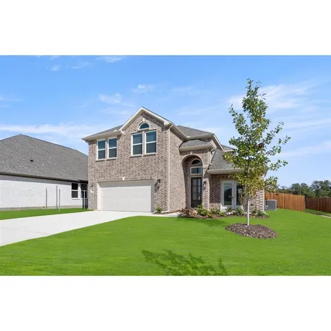 a front view of a house with a yard and trees