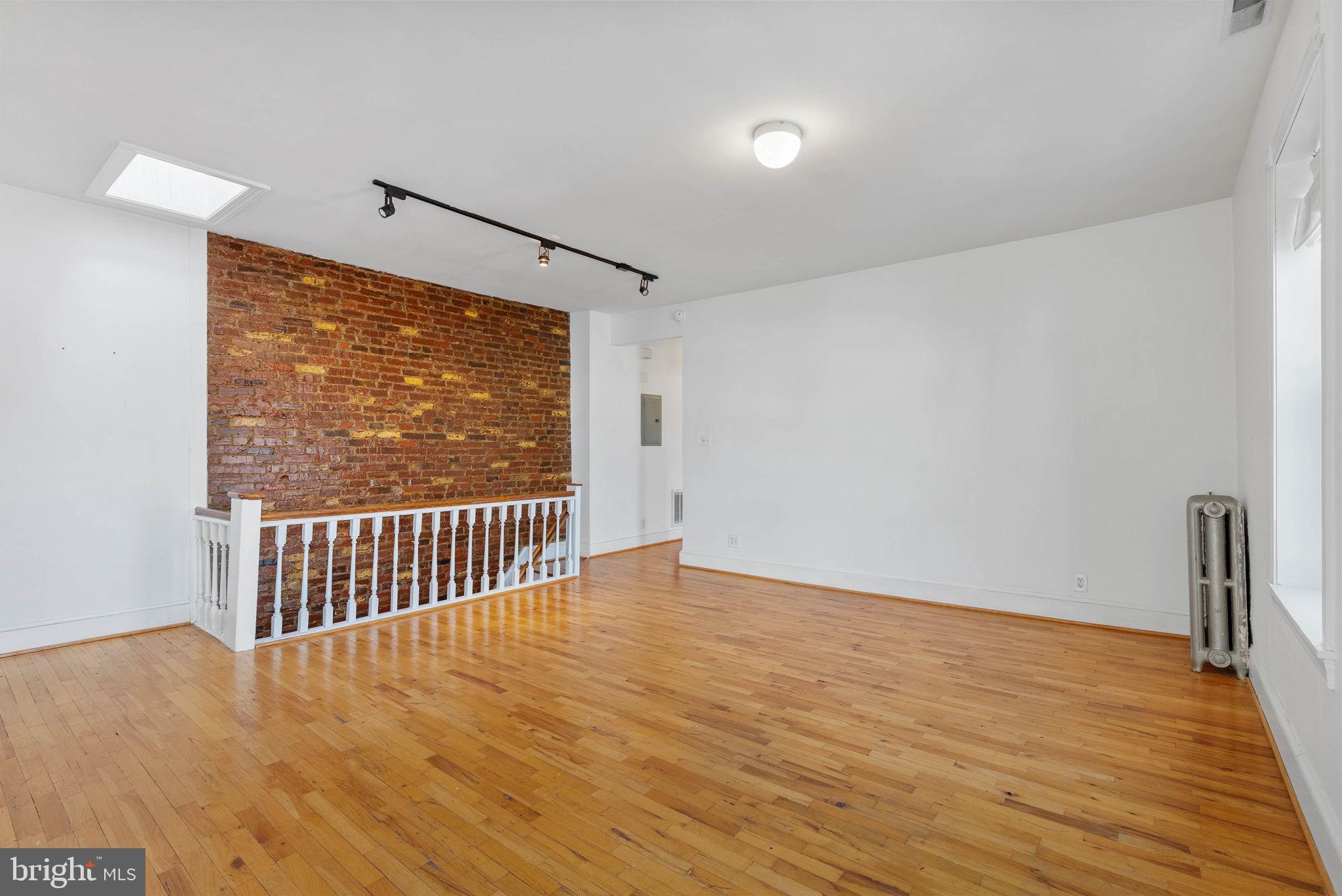 732 Tasker Street, Unit 3 Philadelphia, PA 19148 - Photo 3 of 9 a view of an empty room with wooden floor and a window