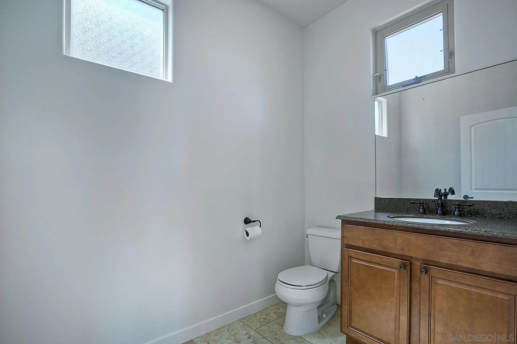 2009 MacKinnon Avenue Encinitas, CA 92007 - Photo 27 of 46 a bathroom with a granite countertop sink a toilet and mirror