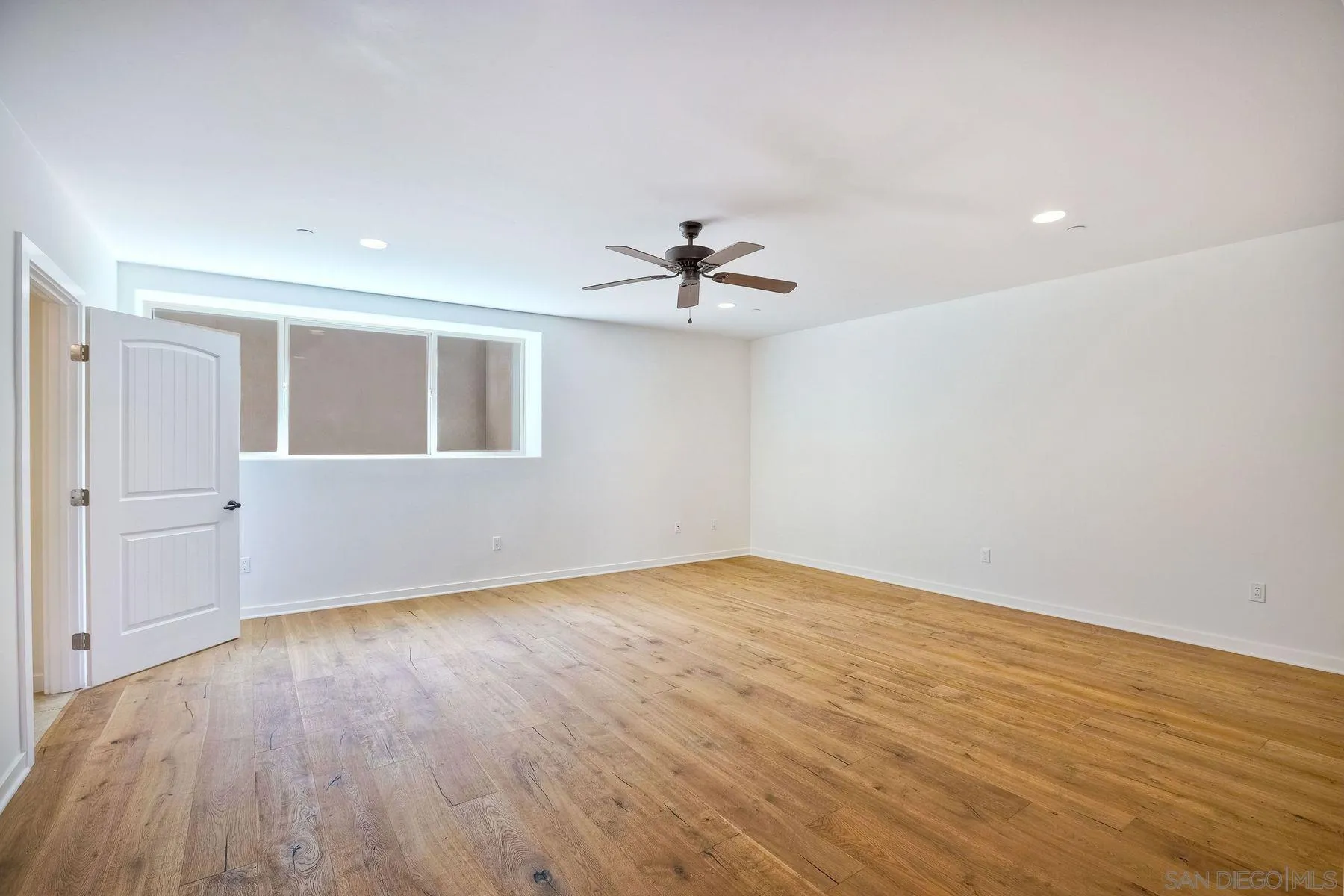 2009 MacKinnon Avenue Encinitas, CA 92007 - Photo 30 of 46 a view of an empty room with wooden floor and a ceiling fan