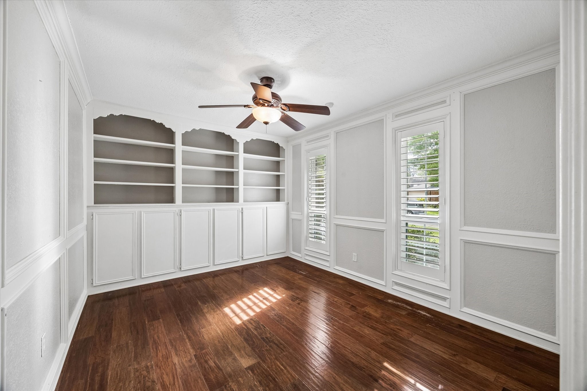 9410 Taidswood Drive Spring, TX 77379 - Photo 12 of 40 The home office/study offers beautiful custom built in shelving and storage and has beautiful hard wood floors with two windows facing out to the street and the beautiful landscaping.