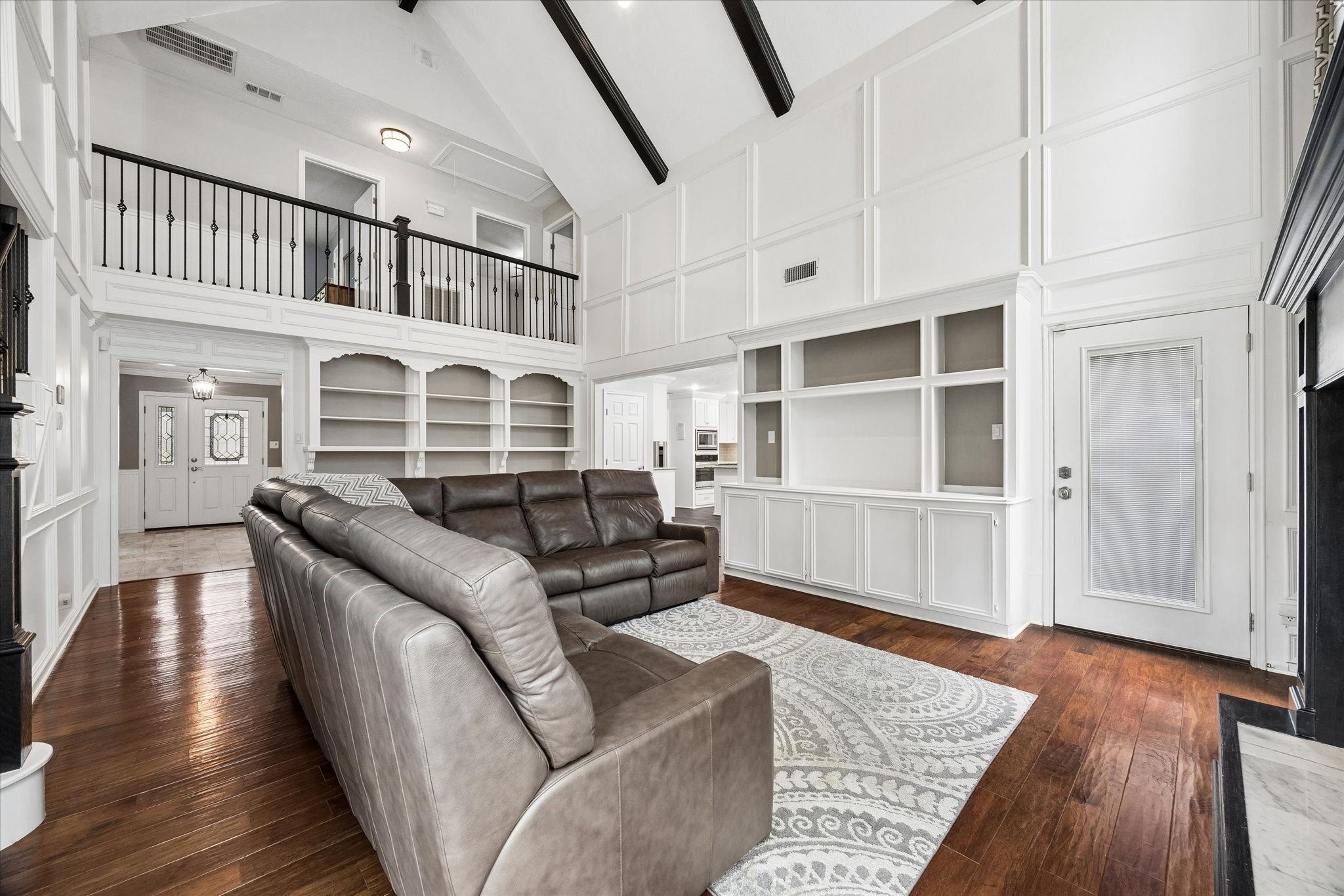 9410 Taidswood Drive Spring, TX 77379 - Photo 17 of 40 Another angle of the beautiful family room showing the upstairs walk way and the two walls with built in cabinets and shelves!