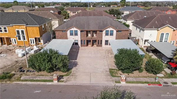 an aerial view of residential houses with outdoor space and parking