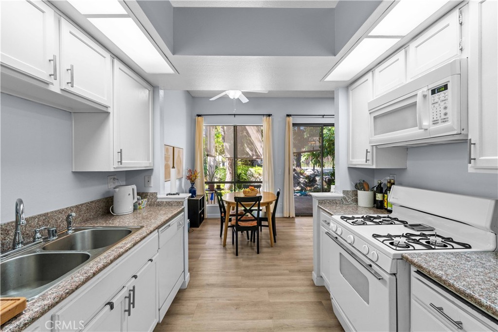 4900 North Grand Avenue, Unit 131 Covina, CA 91724 - Photo 3 of 12 a kitchen with a stove top oven sink and cabinets