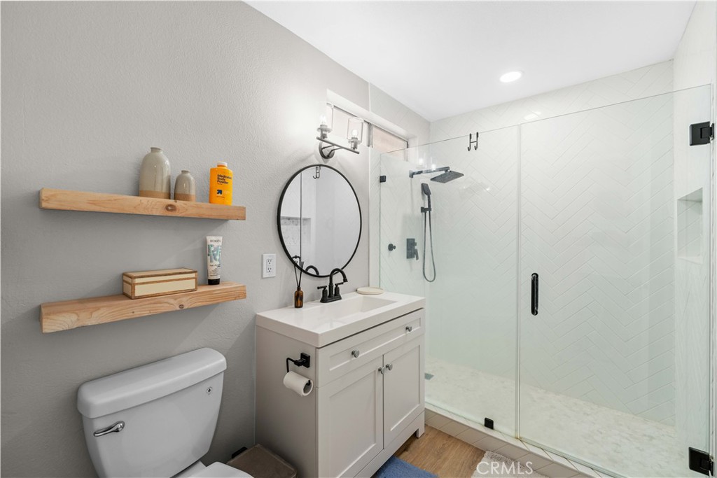 4900 North Grand Avenue, Unit 131 Covina, CA 91724 - Photo 10 of 12 a bathroom with a toilet sink and mirror