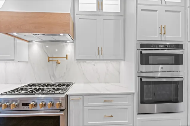 a stove top oven sitting inside of a kitchen