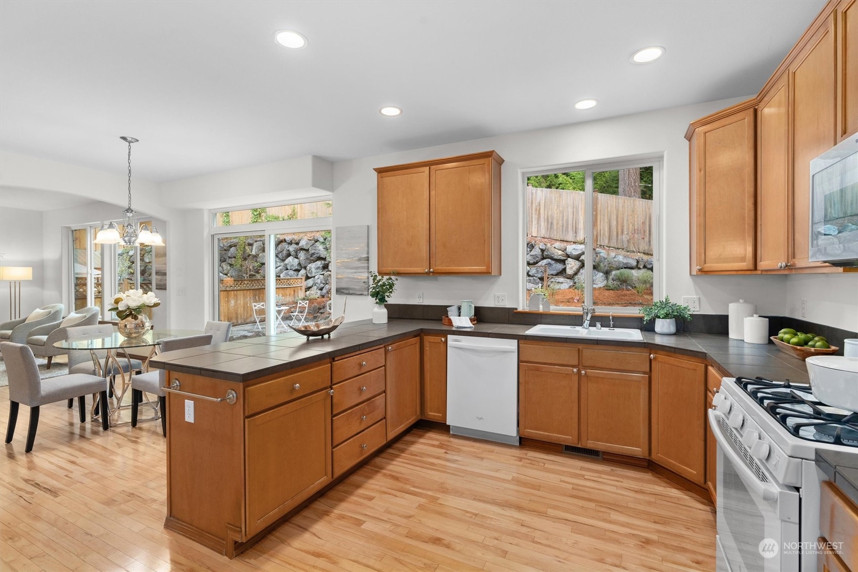18705 13th Drive Southeast Bothell, WA 98012 - Photo 15 of 40 a kitchen with stainless steel appliances granite countertop wooden cabinets a sink dishwasher a stove and a refrigerator with wooden floor