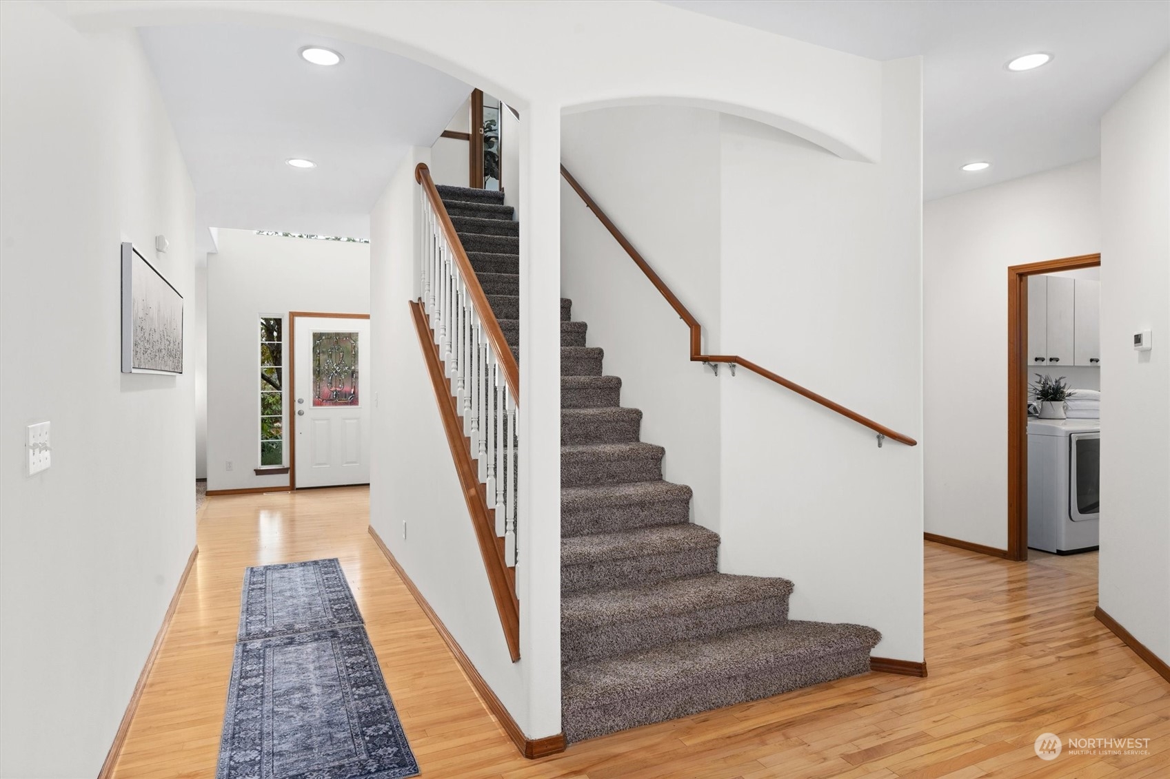 18705 13th Drive Southeast Bothell, WA 98012 - Photo 18 of 40 a view of staircase with lots of frames on wall and wooden floor