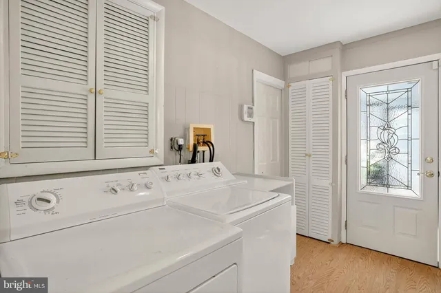 a view of washer and dryer with bathroom in the background