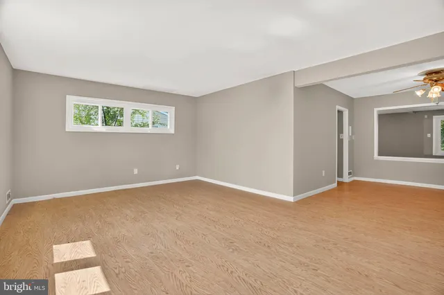 a view of an empty room with window and closet