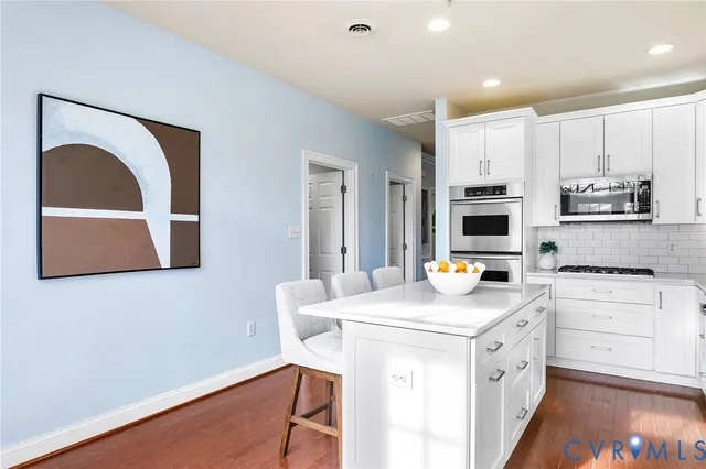 a living room with couches a mirror and a potted plant