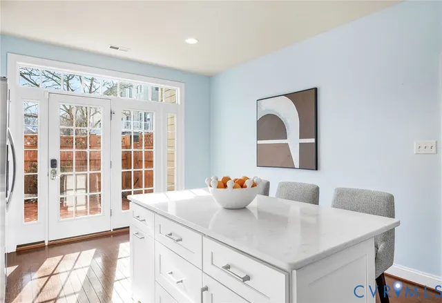 a kitchen with a table chairs and wooden floor