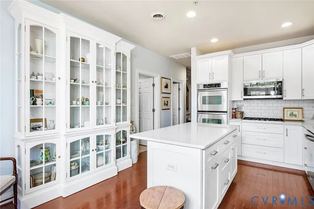 a kitchen with stainless steel appliances granite countertop white cabinets a sink and dishwasher