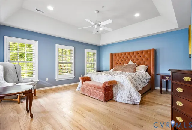 a bedroom with a bed a couch and a large window