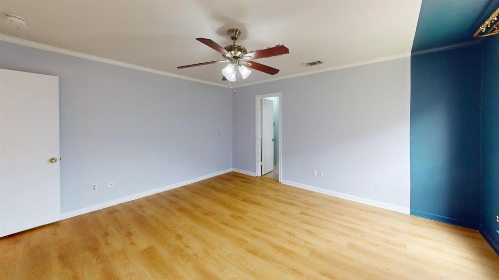 1535 Raleigh Drive Carrollton, TX 75007 - Photo 13 of 24 Spacious room featuring wood-finish flooring, light blue and accent blue walls, white trim, and a ceiling fan with integrated lighting