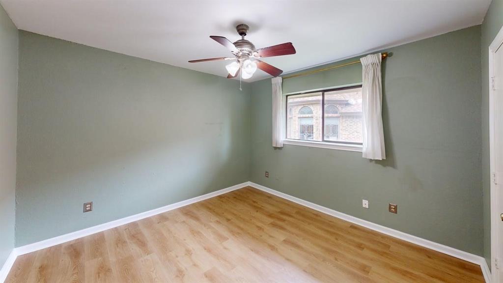 1535 Raleigh Drive Carrollton, TX 75007 - Photo 16 of 24 Bedroom featuring wood-finish flooring, a ceiling fan with integrated lighting, and a window with white trim