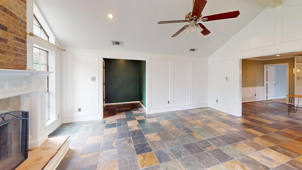 1535 Raleigh Drive Carrollton, TX 75007 - Photo 9 of 24 Living area featuring multi-toned slate tile flooring and a vaulted ceiling