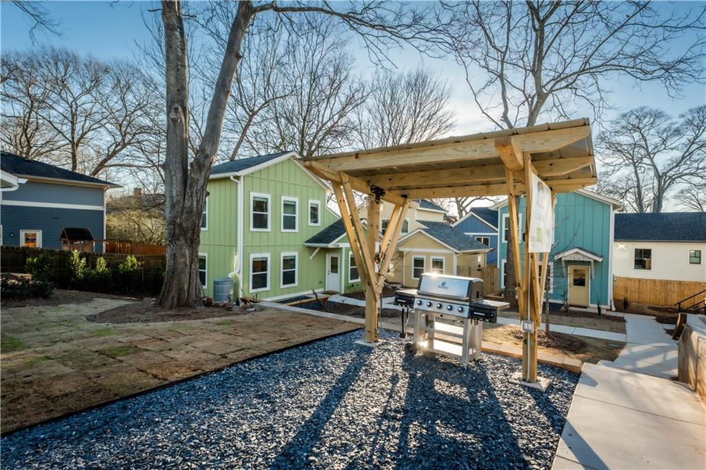 1359 Finley Street Northeast, Unit C Atlanta, GA 30307 - Photo 14 of 19 a view of a white house next to a yard with lawn chairs and a fire pit
