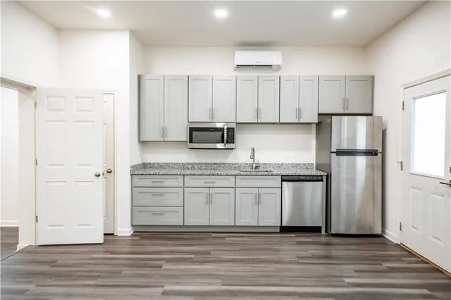 a kitchen with stainless steel appliances granite countertop a refrigerator sink and white cabinets