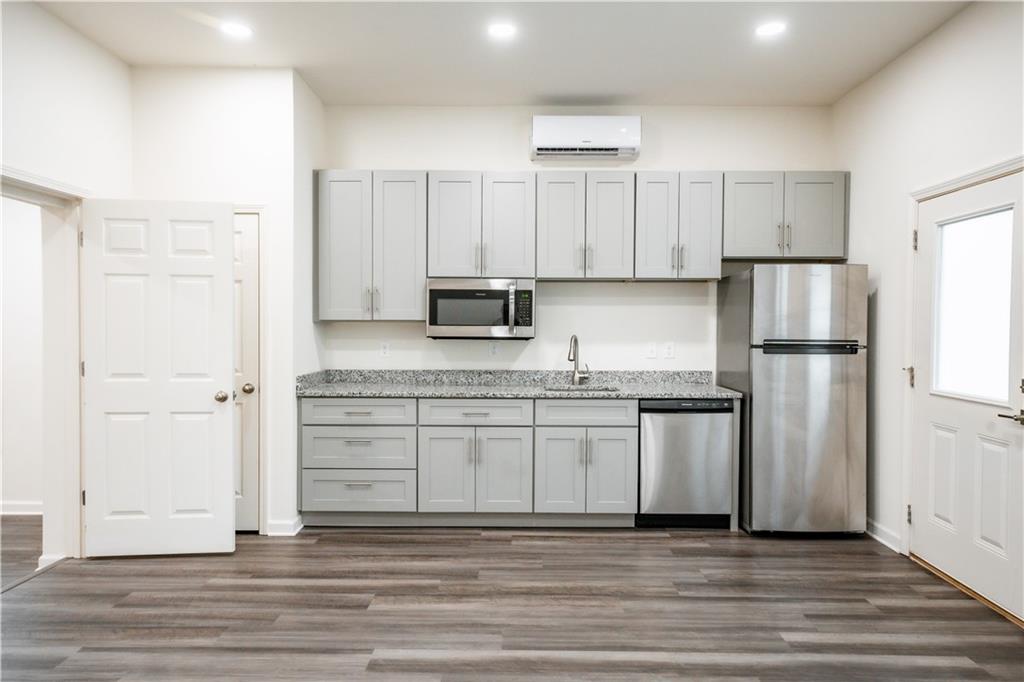 1359 Finley Street Northeast, Unit C Atlanta, GA 30307 - Photo 4 of 19 a kitchen with stainless steel appliances granite countertop a refrigerator sink and white cabinets