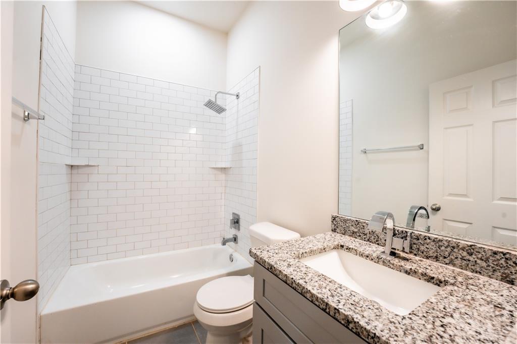 1359 Finley Street Northeast, Unit C Atlanta, GA 30307 - Photo 10 of 19 a bathroom with a granite countertop bathtub shower sink vanity mirror and toilet