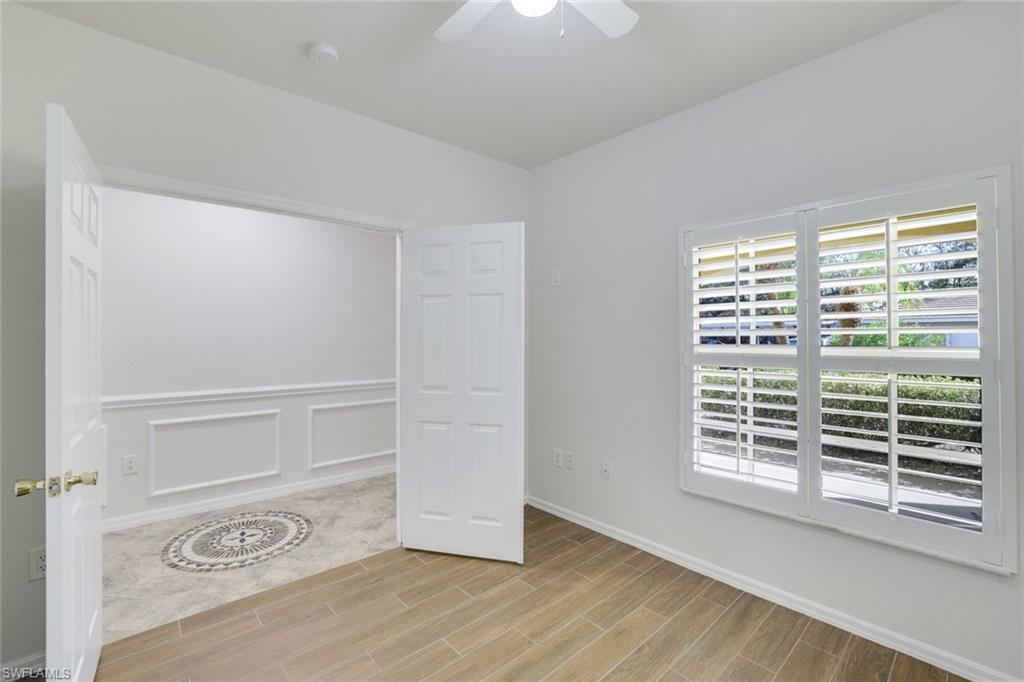 4530 Botanical Pl Circle, Unit 103 Naples, FL 34112 - Photo 4 of 32 Unfurnished bedroom featuring ceiling fan