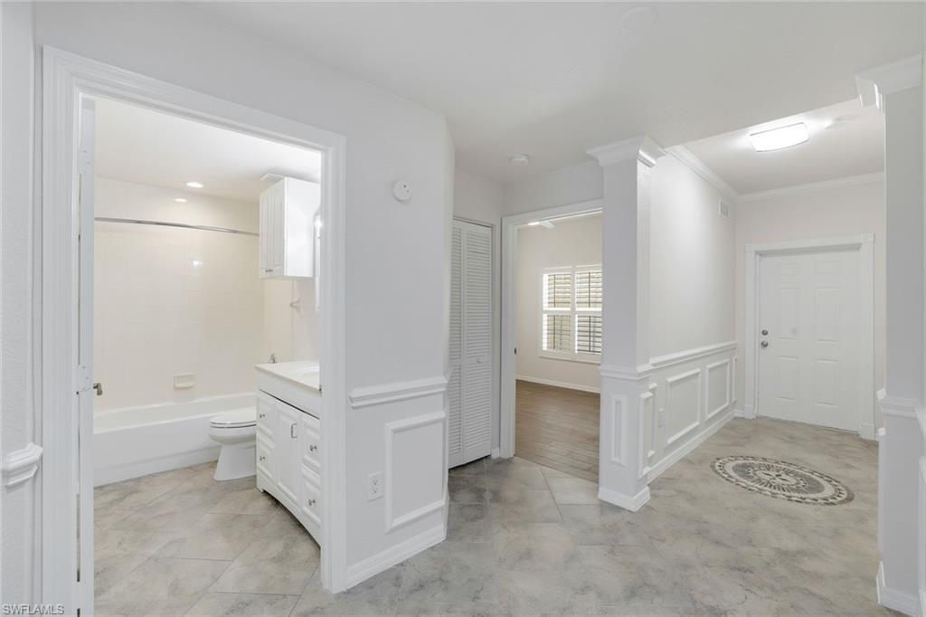 4530 Botanical Pl Circle, Unit 103 Naples, FL 34112 - Photo 9 of 32 Hallway with crown molding and decorative columns