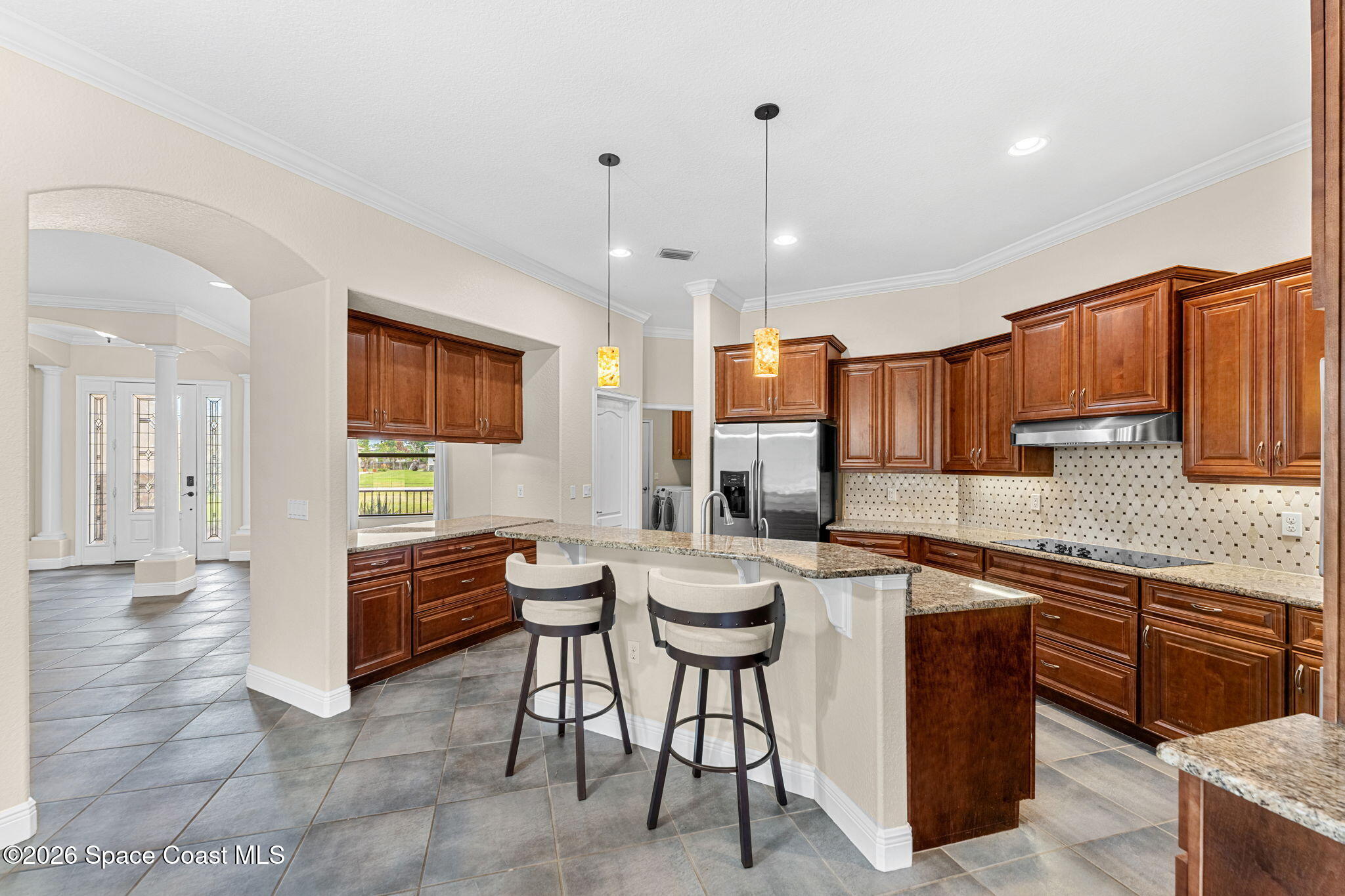 4148 Anlow Road Melbourne, FL 32904 - Photo 12 of 67 a kitchen with stainless steel appliances granite countertop table chairs sink and cabinets