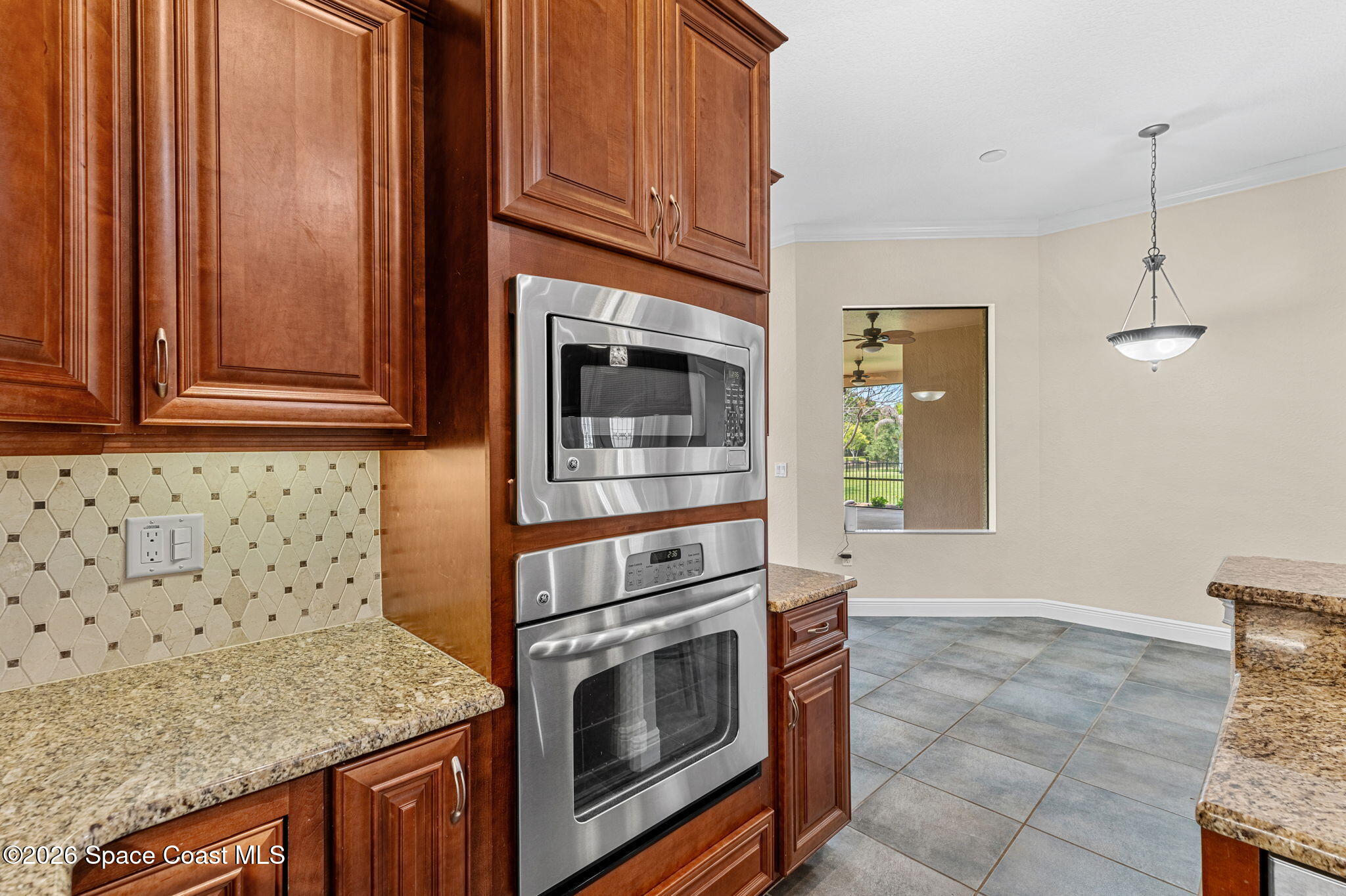 4148 Anlow Road Melbourne, FL 32904 - Photo 16 of 67 a kitchen with granite countertop a stove top oven microwave and cabinets