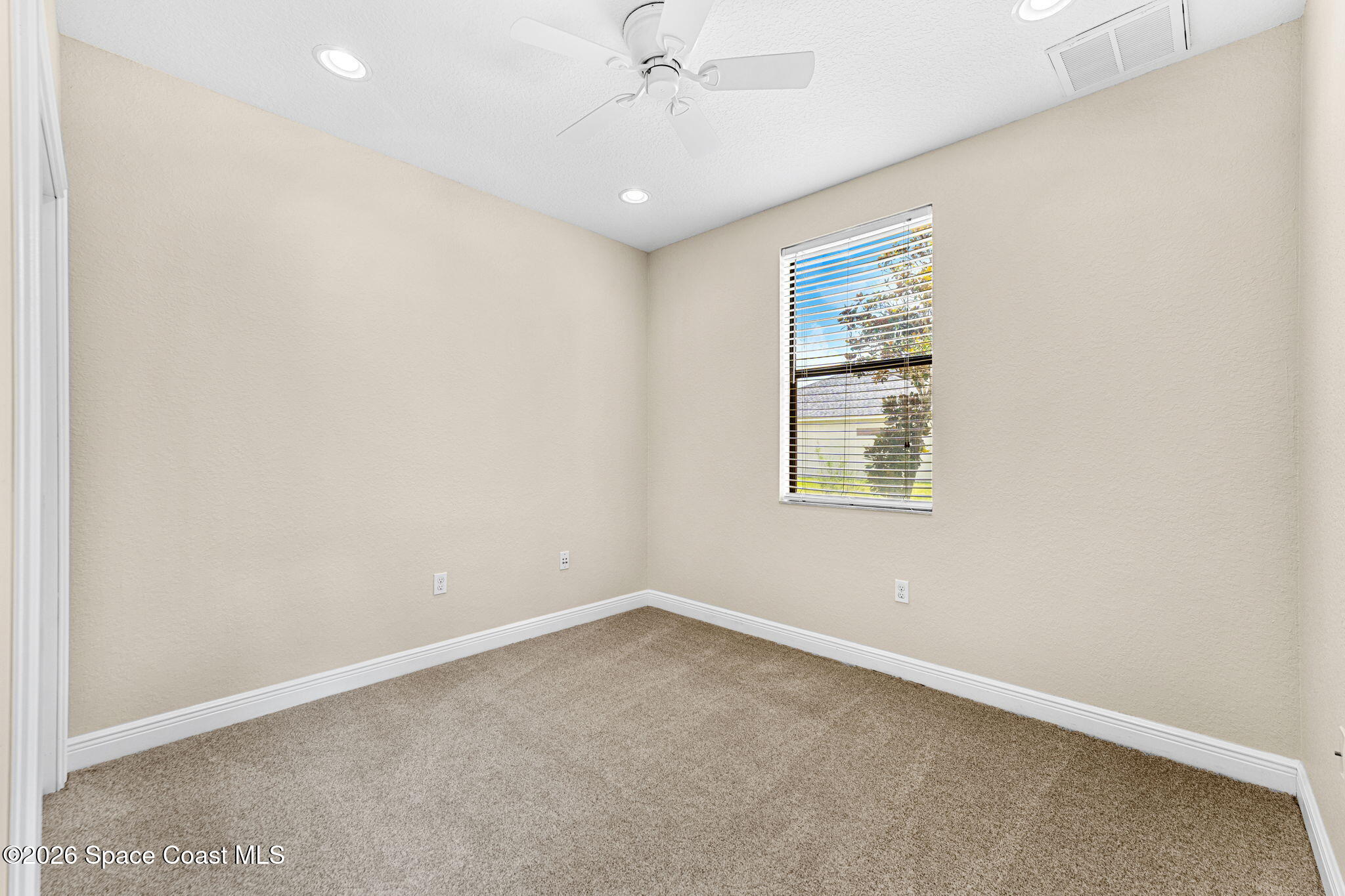 4148 Anlow Road Melbourne, FL 32904 - Photo 28 of 67 an empty room with chandelier fan and windows