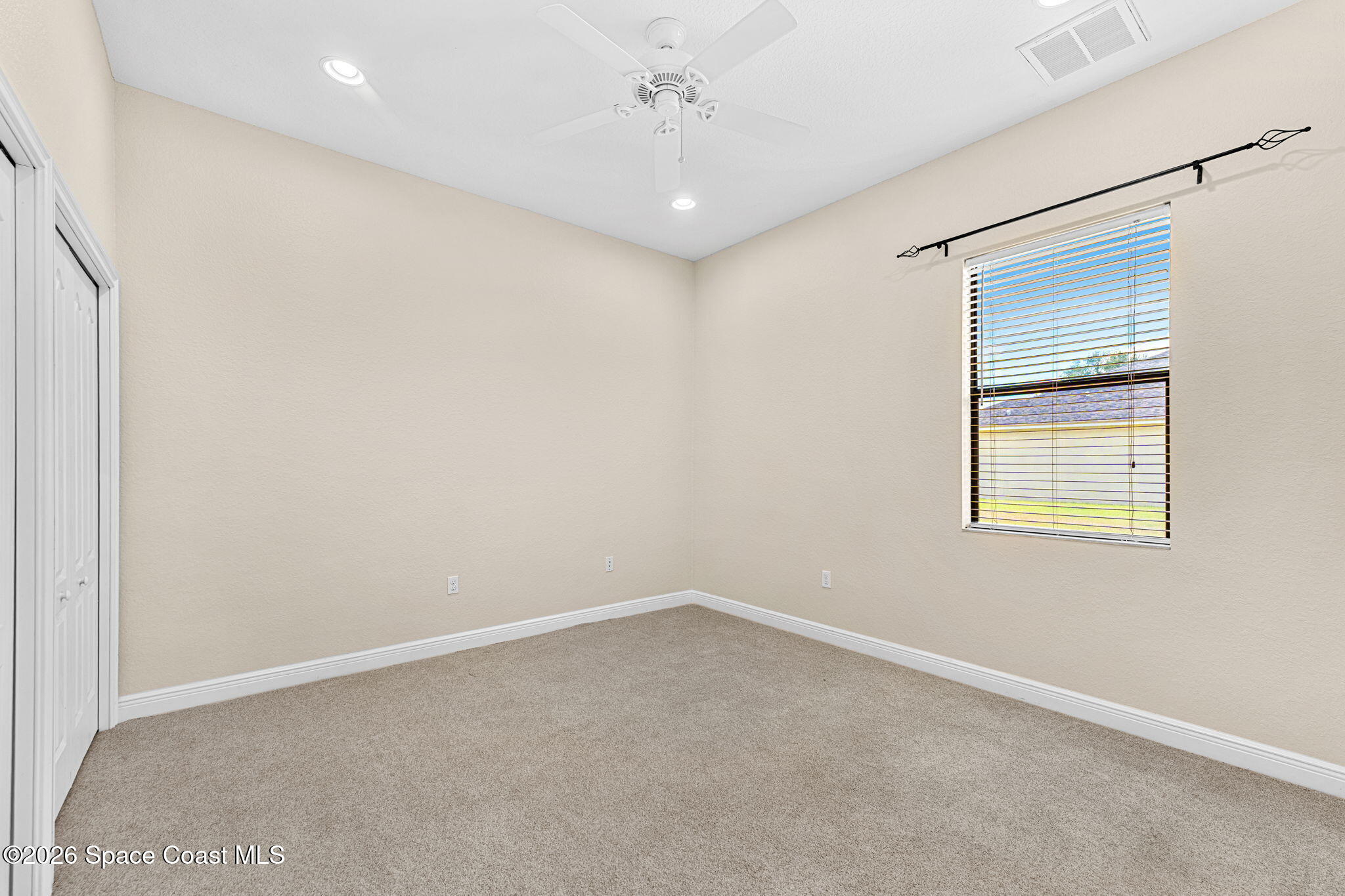 4148 Anlow Road Melbourne, FL 32904 - Photo 31 of 67 an empty room with a chandelier fan and windows