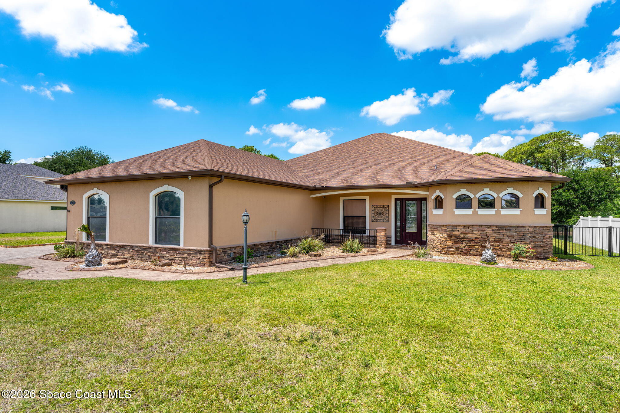 4148 Anlow Road Melbourne, FL 32904 - Photo 61 of 67 a backyard of a house with table and chairs under an umbrella