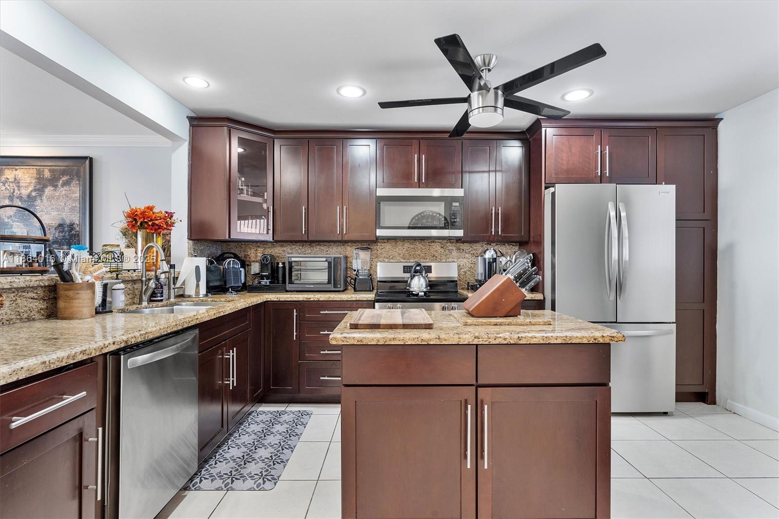 4000 Northeast 168th Street, Unit PH5A North Miami Beach, FL 33160 - Photo 6 of 33 a kitchen with kitchen island a cabinets a counter top space and stainless steel appliances