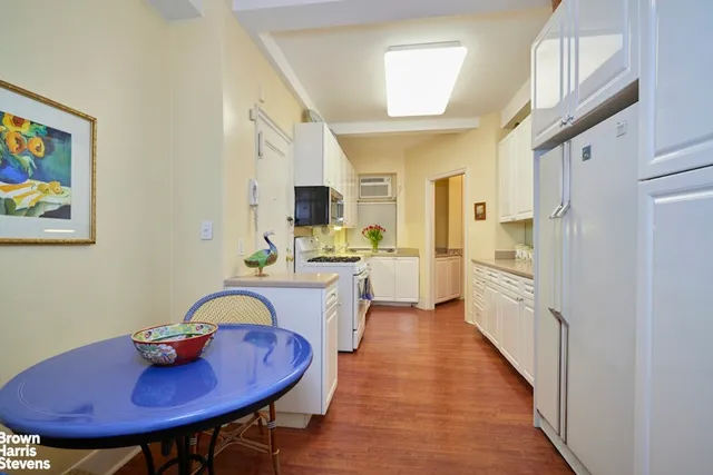 a view of a hallway with wooden floor and a living room