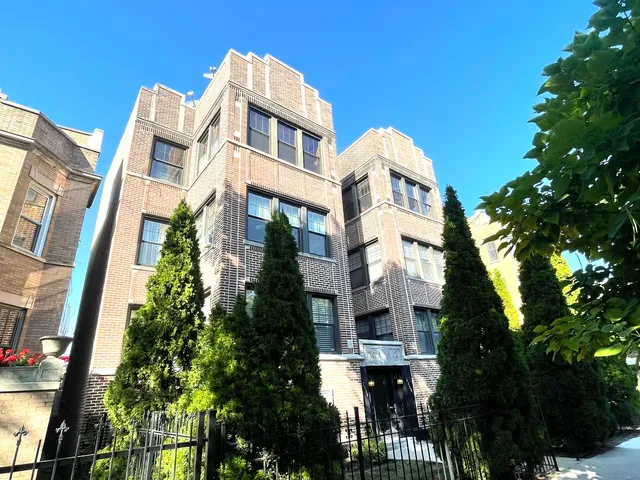 a front view of a multi story residential apartment building with a yard