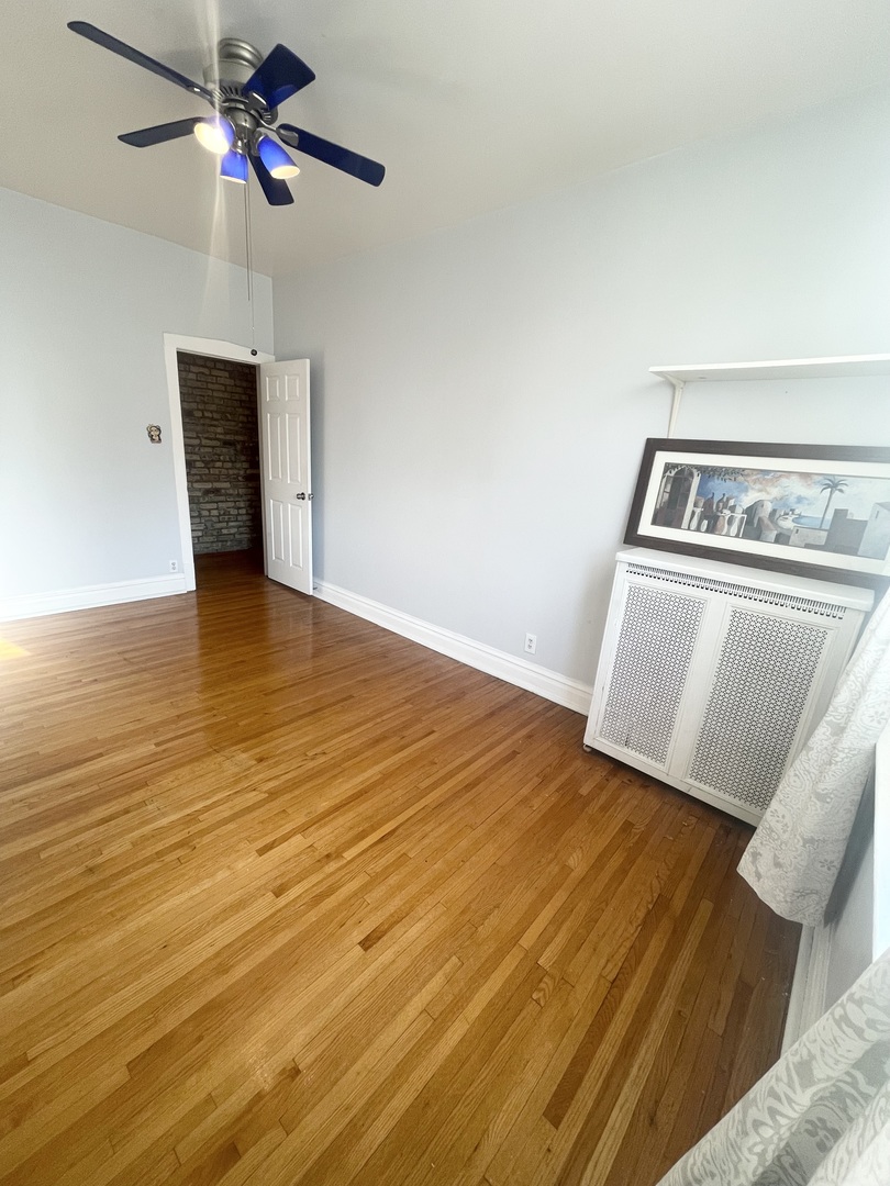 2810 West Logan Boulevard, Unit 3W Chicago, IL 60647 - Photo 21 of 34 a view of an empty room with chandelier fan and wooden floor